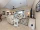 Bright living room featuring a stylish neutral sectional, tile flooring, and a seamless transition to the outdoor pool area at 2198 Chenille Ct, Venice, FL 34292