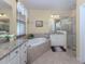 Bright bathroom with dual vanities, large tub, and glass enclosed shower at 2198 Chenille Ct, Venice, FL 34292