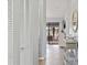 Bright hallway with gray wood floors, louvered closet doors and table for decor at 1027 Capri Isles Blvd # 22, Venice, FL 34292