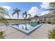 Inviting community pool with clear blue water, surrounded by tropical palm trees and lush greenery at 1027 Capri Isles Blvd # 22, Venice, FL 34292