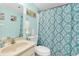 Bright bathroom featuring sink, toilet, and shower with a lovely shower curtain design at 104 Capri Isles Blvd # 302, Venice, FL 34292