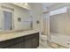 Bright bathroom with granite countertops, tile surround tub, and a large mirror at 11810 Tapestry Ln, Venice, FL 34293
