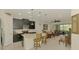 Open layout connects the living room to a modern kitchen with an island and bar seating at 11810 Tapestry Ln, Venice, FL 34293