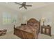 Main bedroom features a tray ceiling, shuttered windows, and wood furniture at 11810 Tapestry Ln, Venice, FL 34293