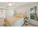 Bright bedroom featuring natural light, tile flooring, a ceiling fan and a comfortable bed with a plaid comforter at 1201 Ewing St, Nokomis, FL 34275