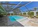 Wide angle of the screened-in pool area with patio and mature tropical landscaping at 1201 Ewing St, Nokomis, FL 34275