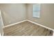 An empty bedroom features wood-look floors and neutral walls, brightened by natural light at 12316 Durango Ave, North Port, FL 34287