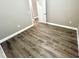 An empty bedroom featuring wood-look floors and neutral wall color with a crisp white door at 12316 Durango Ave, North Port, FL 34287