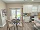Cozy dining area with a glass table, four chairs, and adjacent to a modern kitchen with backyard views at 12316 Durango Ave, North Port, FL 34287