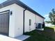 Side exterior featuring a well-manicured lawn and a garage with a neutral colored door at 12316 Durango Ave, North Port, FL 34287