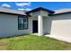 Charming home exterior featuring a modern front door, a well-manicured lawn and tasteful landscaping at 12316 Durango Ave, North Port, FL 34287