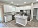 Modern kitchen with white cabinets, granite countertops, stainless steel appliances, and an island at 12316 Durango Ave, North Port, FL 34287