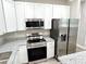Close up of kitchen featuring stainless steel appliances, and modern white cabinetry and granite countertops at 12316 Durango Ave, North Port, FL 34287