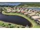 Aerial view of a tile roofed home and neighborhood surrounding a pond and golf course at 129 Cipriani Way, North Venice, FL 34275