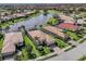 Aerial view of a single-Gathering home with a screened-in pool and lush landscaping overlooking a lake at 129 Cipriani Way, North Venice, FL 34275