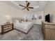 Serene bedroom with a plush bed, ceiling fan, neutral decor, and ample natural light at 129 Cipriani Way, North Venice, FL 34275