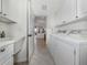 Bright laundry room with white cabinets, washer, dryer, utility sink, and tile flooring at 129 Cipriani Way, North Venice, FL 34275