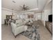 Spacious living room featuring an open floor plan, a large ceiling fan, and a view into the kitchen area at 129 Cipriani Way, North Venice, FL 34275