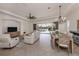 Open concept living room and dining area with a view of the screened-in pool and lake beyond at 129 Cipriani Way, North Venice, FL 34275