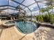 View of screened in pool and spa with waterfalls and lush landscaping at 129 Cipriani Way, North Venice, FL 34275