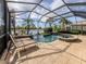 View of screened in pool and spa with lounge chairs and lush landscaping at 129 Cipriani Way, North Venice, FL 34275