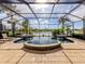 Stunning screened-in pool with integrated spa and waterfall features, overlooking a serene lake at 129 Cipriani Way, North Venice, FL 34275