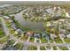 Expansive aerial shot of a neighborhood built around a large canal, featuring manicured lawns and diverse home styles at 1300 Lucaya Ave, Venice, FL 34285