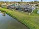 Waterfront backyard featuring a screened-in pool, lush lawn, and mature trees at 1300 Lucaya Ave, Venice, FL 34285