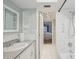 Bright bathroom featuring tiled walls, open shelving and a view into the bedroom at 1300 Lucaya Ave, Venice, FL 34285