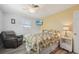 Relaxing bedroom featuring a window, ceiling fan, and comfortable seating area at 1300 Lucaya Ave, Venice, FL 34285