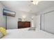 Clean bedroom with a ceiling fan, TV, wood dresser, and ensuite bathroom; features white bedding at 1300 Lucaya Ave, Venice, FL 34285