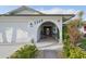 Charming arched entryway featuring a seating area and lush landscaping, number for the house is visible at 1300 Lucaya Ave, Venice, FL 34285