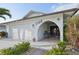 Inviting entrance with seating area, elegant archway, and well maintained landscaping, with a two car garage at 1300 Lucaya Ave, Venice, FL 34285