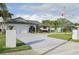 Attractive single-story home with a wide driveway and vibrant landscaping, featuring an American flag at 1300 Lucaya Ave, Venice, FL 34285