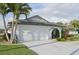 Bright single-story home with attached garage, lush lawn and tropical landscaping, showcasing curb appeal at 1300 Lucaya Ave, Venice, FL 34285