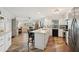 Modern kitchen with white cabinetry, island seating, stainless steel appliances, and wood floors at 1300 Lucaya Ave, Venice, FL 34285