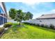 Manicured backyard featuring a green lawn, shrubbery, trees, and a privacy wall at 1330 Berkshire Ct, Venice, FL 34292