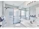 Well-lit bathroom featuring a tub and shower with a glass sliding door and vanity at 1330 Berkshire Ct, Venice, FL 34292