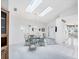 Bright dining room with skylights, glass table, and seating for six at 1330 Berkshire Ct, Venice, FL 34292