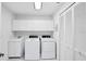 Bright laundry room with washer, dryer, storage cabinets, and large closet at 1330 Berkshire Ct, Venice, FL 34292