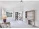 Bright living room with ceiling fan, neutral carpeting, and desk with shelving at 1330 Berkshire Ct, Venice, FL 34292