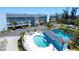 Aerial view of a resort featuring a pool and a pond surrounded by trees at 1401 S Mccall Rd # 106, Englewood, FL 34223