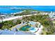Breathtaking aerial view showcases lush landscaping, with a pool, tennis court, parking, and the surrounding waters at 1401 S Mccall Rd # 106, Englewood, FL 34223
