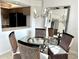 Dining area with a glass table, four woven chairs, chandelier and large mirror at 1401 S Mccall Rd # 106, Englewood, FL 34223