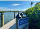 Dock with boaters caution sign featuring a view of the water, surrounding vegetation, and a palm tree at 1401 S Mccall Rd # 106, Englewood, FL 34223