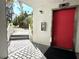 Exterior view of a red elevator entrance surrounded by lush landscaping and a stone pathway at 1401 S Mccall Rd # 106, Englewood, FL 34223