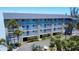 Attractive three-story condo building with white balconies, surrounded by palm trees and lush landscaping at 1401 S Mccall Rd # 106, Englewood, FL 34223