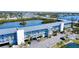 Exterior of the multi-story apartment building featuring a parking lot, lush landscaping, and waterfront views at 1401 S Mccall Rd # 106, Englewood, FL 34223