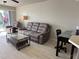 Open living room with comfortable furniture, a ceiling fan, and a sliding glass door to balcony at 1401 S Mccall Rd # 106, Englewood, FL 34223