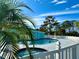 Relaxing community pool area featuring a hot tub, lounge chairs, palm trees, and a light blue building at 1401 S Mccall Rd # 106, Englewood, FL 34223